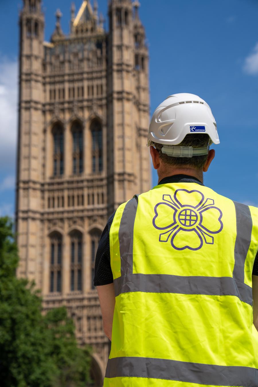 Person in hi-vis in front of Victoria Tower