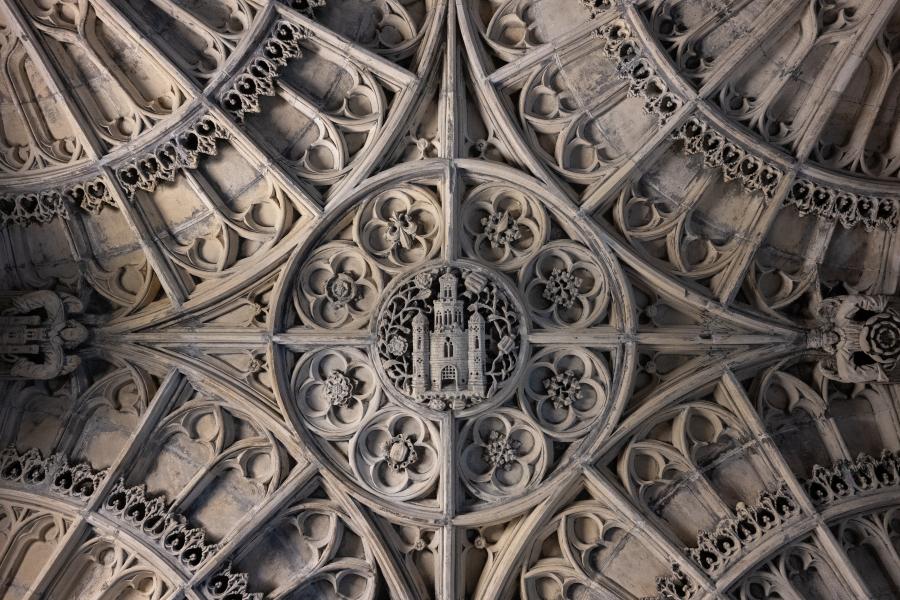 Ornate stone roof showing heraldic symbols with castle in centre including rose and pomegranate